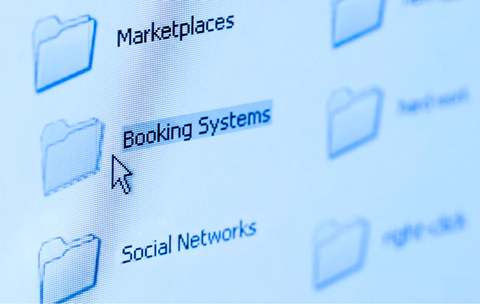 Computer screen showing folder icons with one folder named 'Booking Systems' highlighted and cursor pointing at it.
